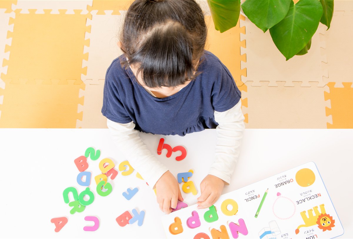 カラフルな文字と教材を使って英語を学ぶ子どもの様子